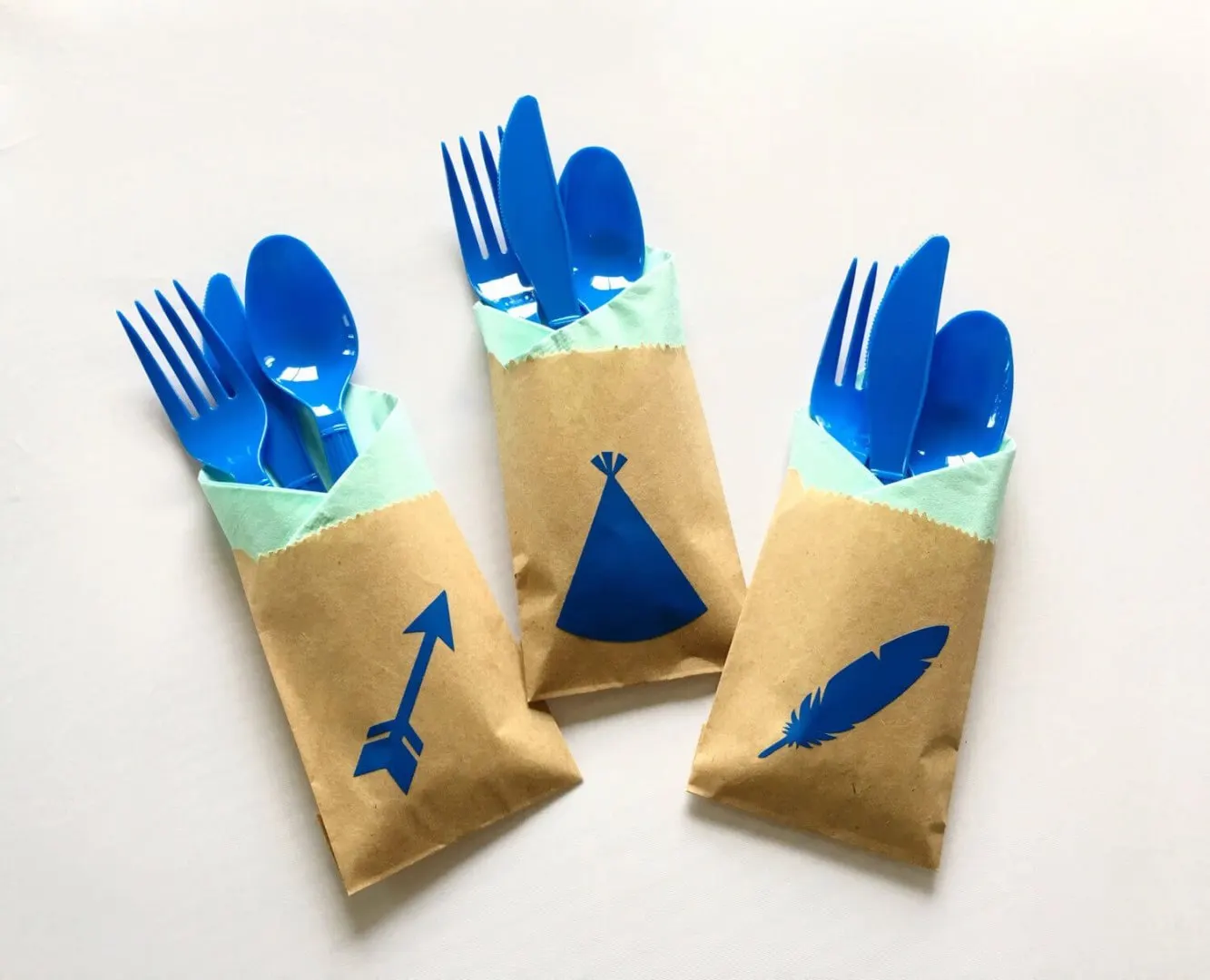 Uma ideia legal é colocar os guardanapos de papel em um saquinho simples (esses de confeitos). Basta imprimir imagens com o tema da festa, colar, encaixar os talheres e pronto. Prático, simples e divertido. Esta mesma ideia pode ser adaptada para festas de adultos: guardanapos brancos da Relevo, talheres dourados e imagens (que tal uma frase!?) em branco.