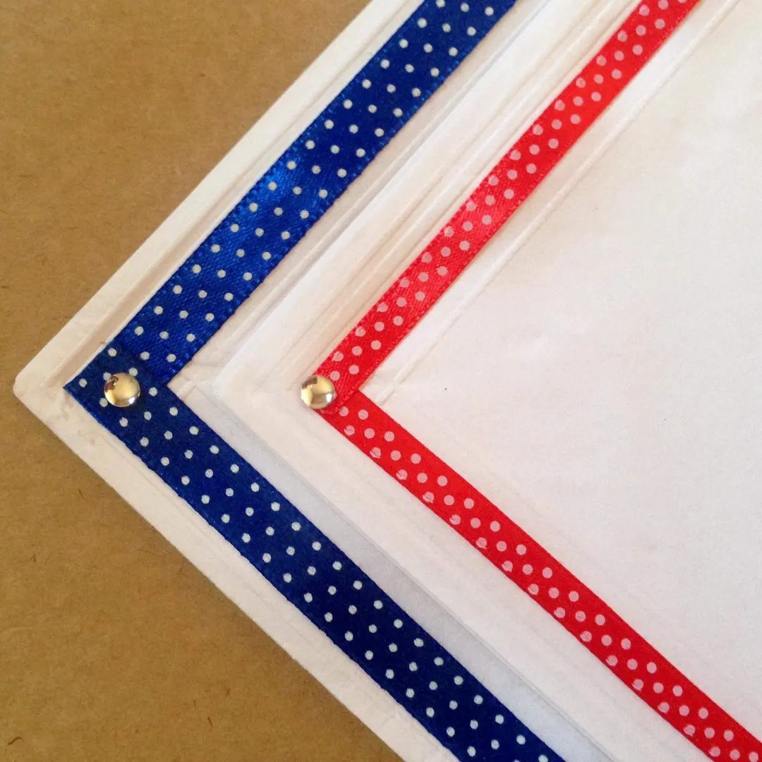 Como decorar guardanapo de papel para jantar romântico e sair do tradicional vermelho: uma boa ideia é colar uma fita no entorno do guardanapo de papel tradicional da Relevo. Arremate com um pontinho de luz. Fica delicado e ao mesmo tempo diferente!
