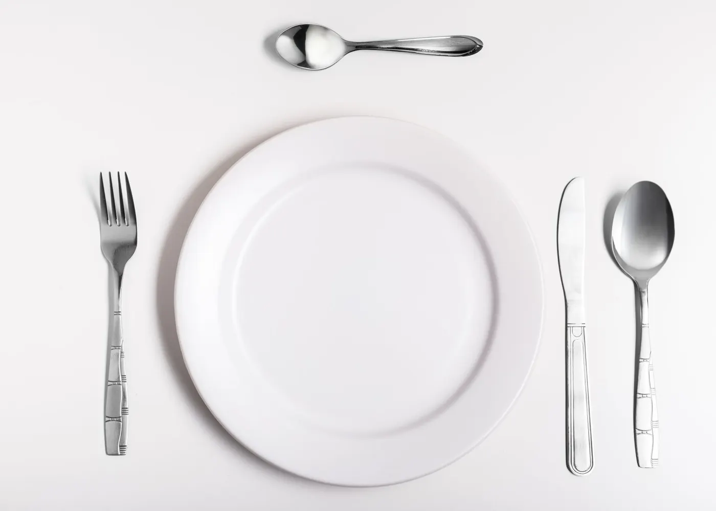 prato e talheres colocados á mesa
