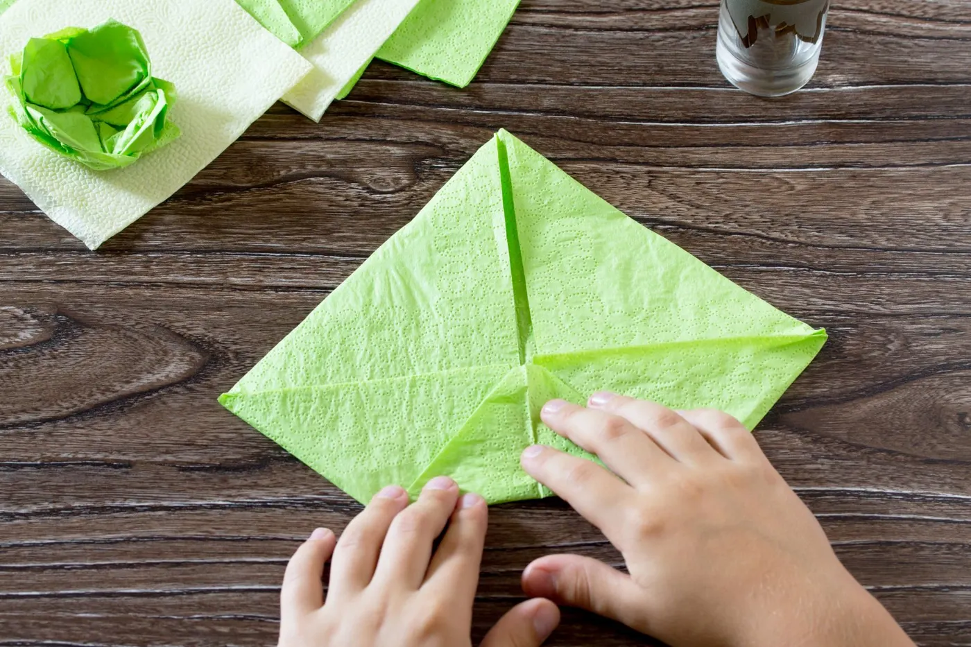criança dobra guardanapo de papel