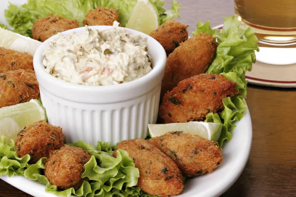 Um bolinho bacalhau acompanhado de um molho fresco e limão. Não tem petisco de bar melhor.